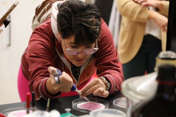 student works in lab with pipet