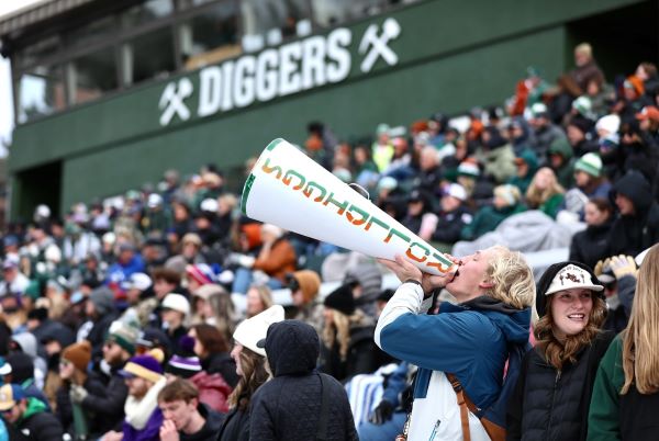 A fan cheers into a "GoDiggers" megaphone. 