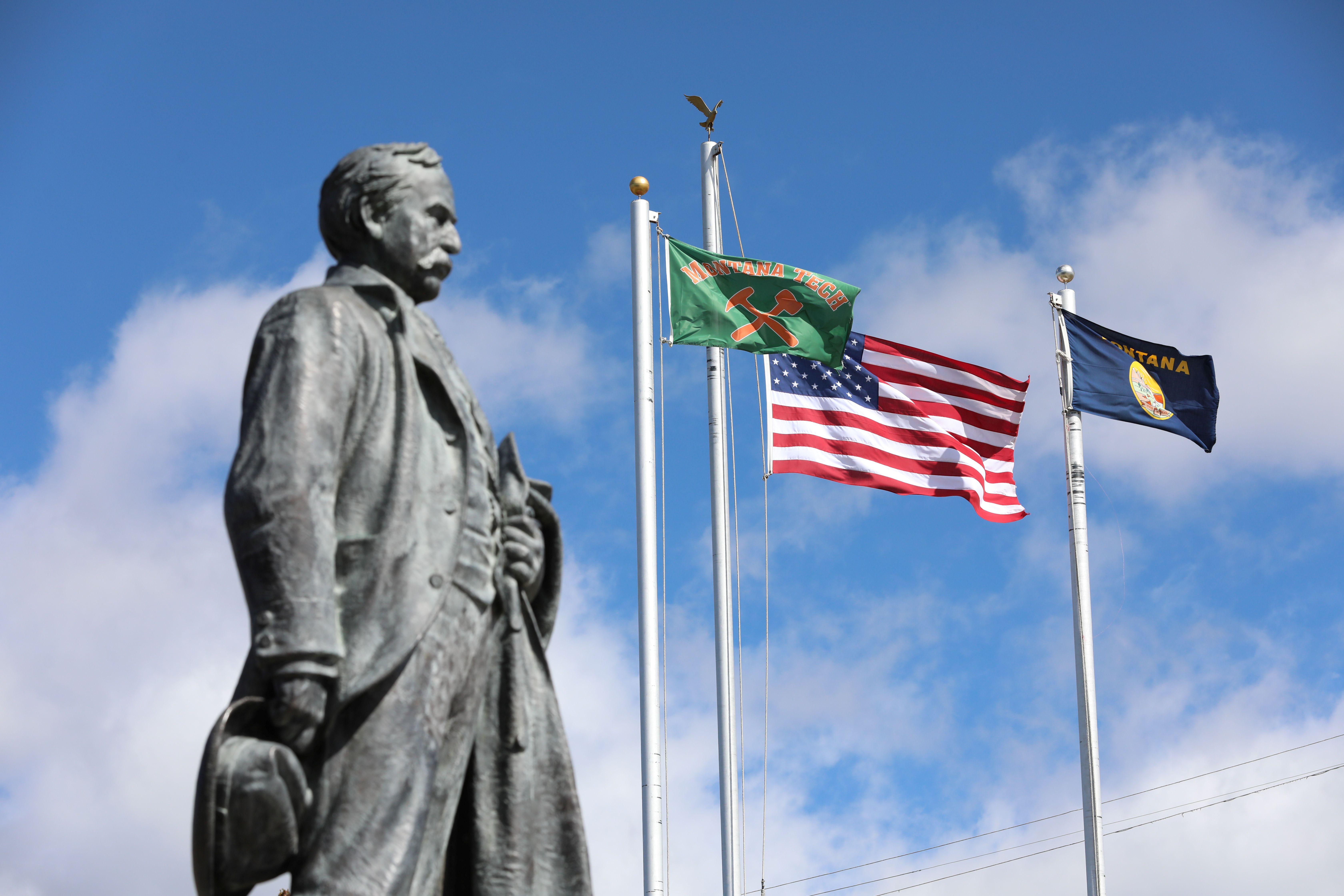 Marcus Daly statue and Montana Tech flags