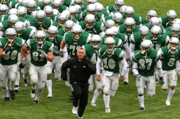 !Coach Bob Green runs on the field with his players. 