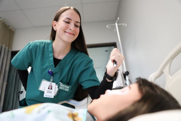Caitlin Olson in the nursing simulation lab with a dummy