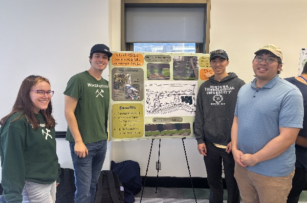 Four Montana Tech students display their project poster