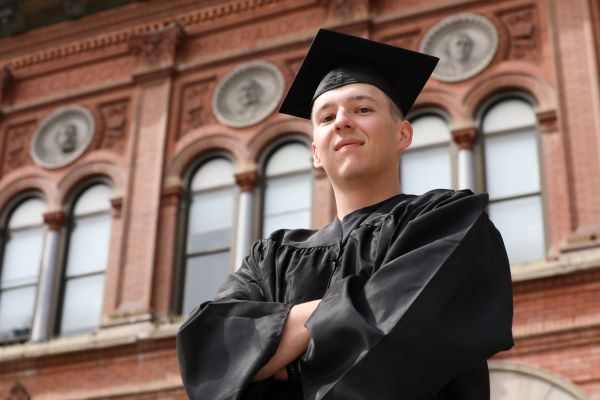 !Nathan Ostwald poses in cap and gown