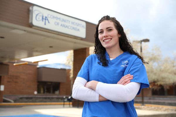 Chloe Jones in scrubs in front of Community Hospital of Anaconda