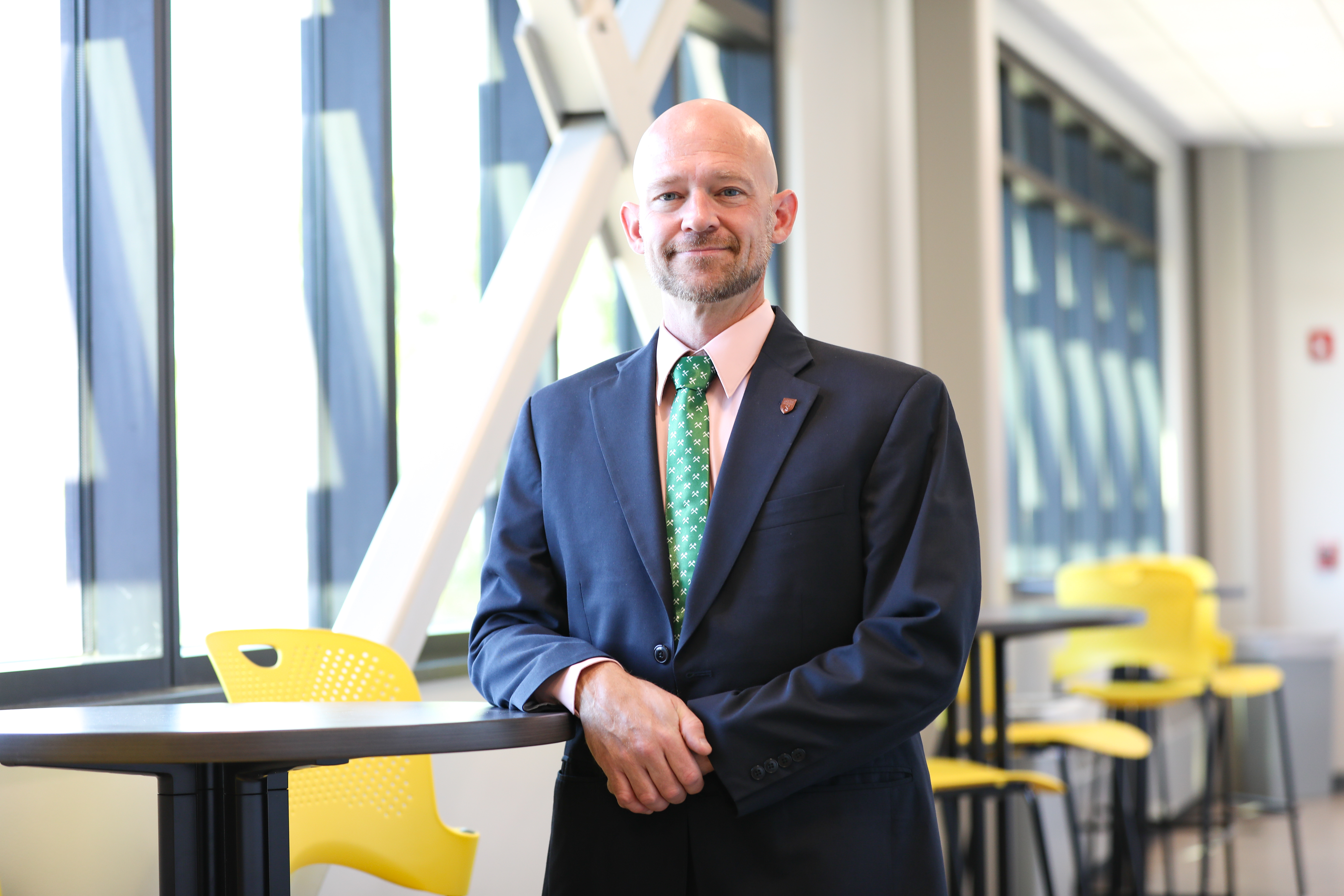 Portrait of Dr. Matthew standing in a building on campus