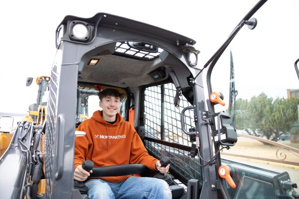 A student drives a skidsteer