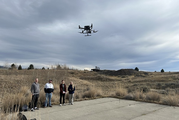 students watch a drone rise