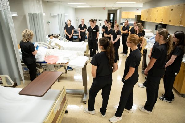 !CNA students observe a demonstration with a dummy