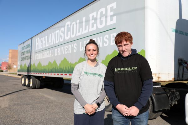 Students and Highlands College representatives pose for a photo in front of a commercial truck