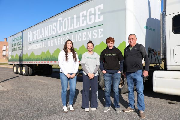 Students and Highlands College representatives pose for a photo in front of a commercial truck