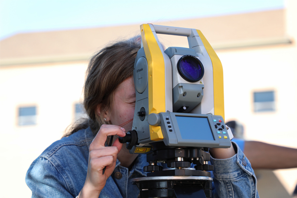 Girl using surveying equipment