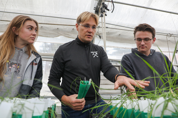 Faculty member, Robert Pal, and students looking at plant samples