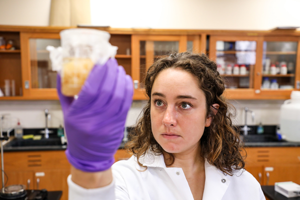 Female student holding a beaker containing fluid