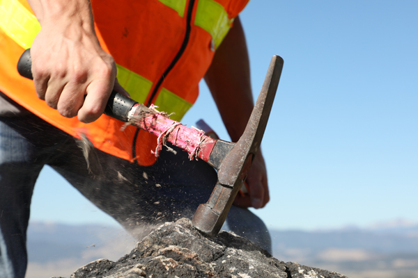 Student hammering a rock