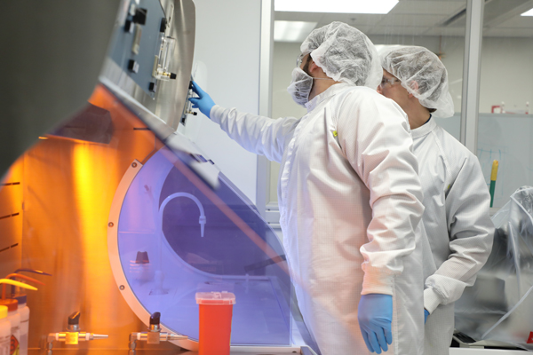 Two people using a machine in a nano-technology lab