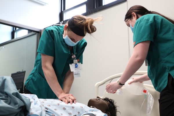 Nursing students performing respiratory procedures on a mannequin 