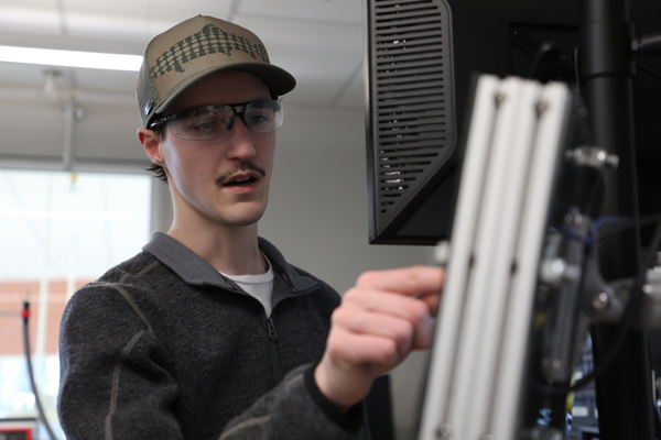 Master's student pointing at a computer monitor