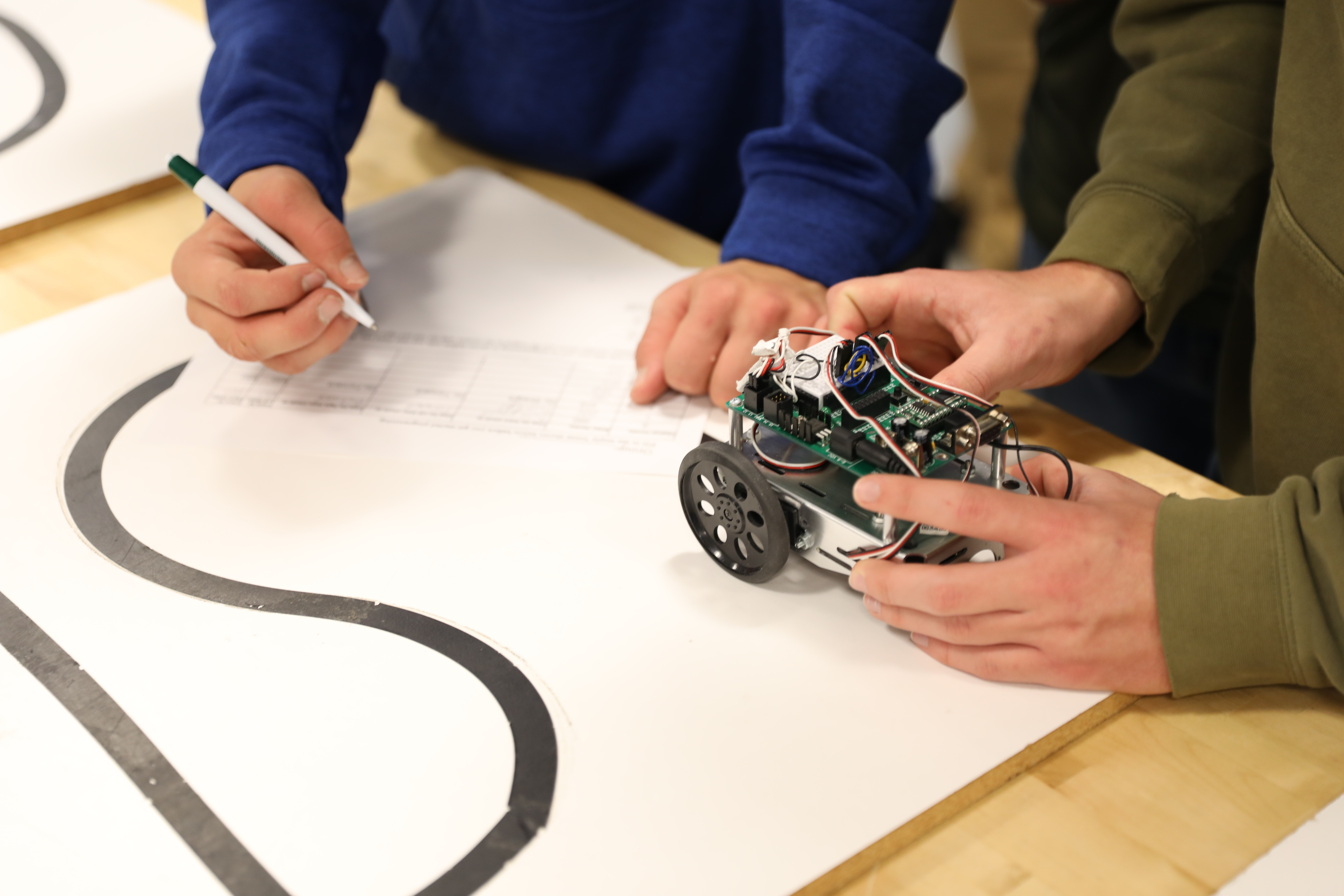 students working on a robotic vehicle. 