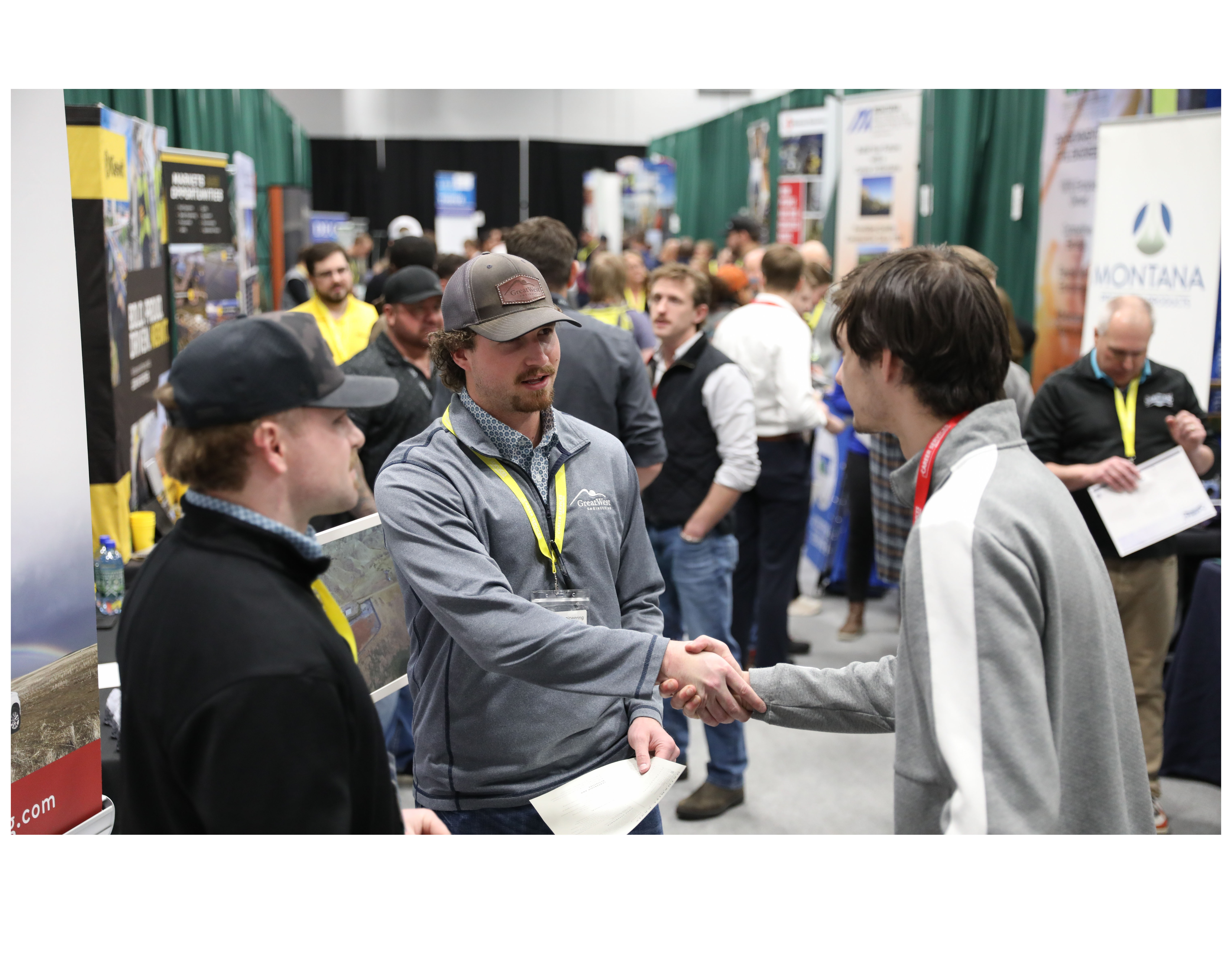 People handshaking at a career fair event.