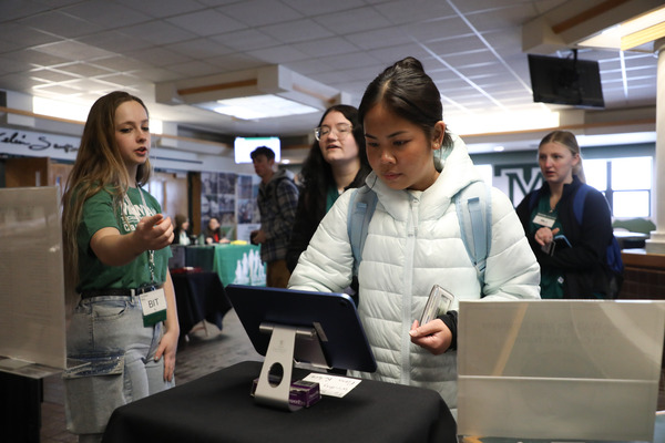 Internship Coordinator helps students check in to the Career Fair.