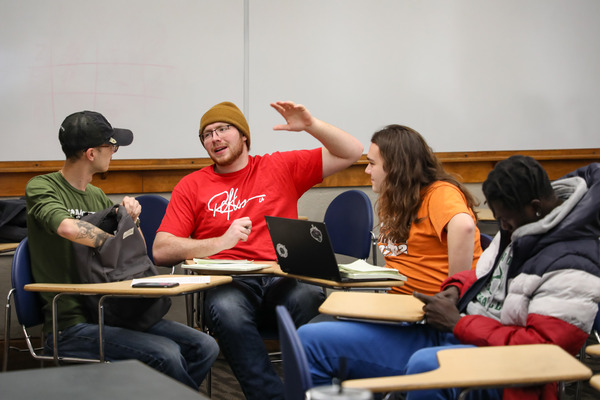 Student raising hand in class.