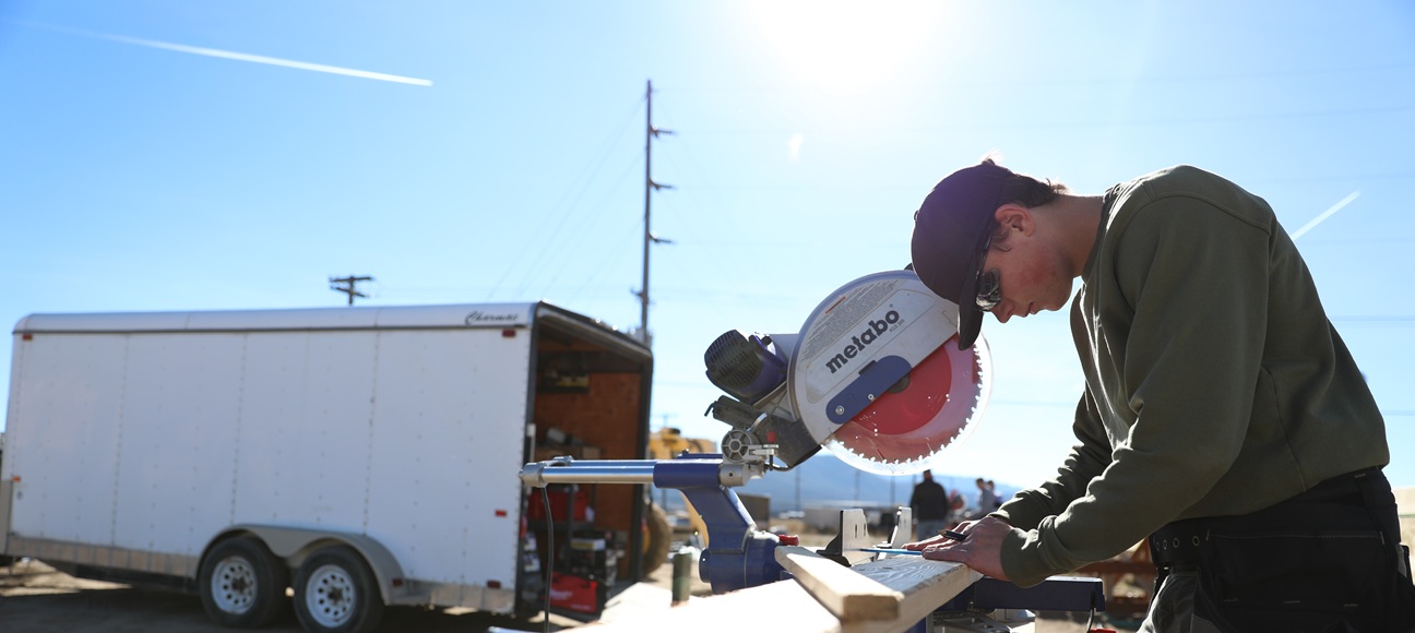 Carpentry student runs a saw. 