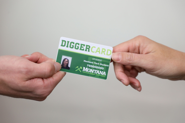 A Montana Tech staff member handing a student their new DiggerCard