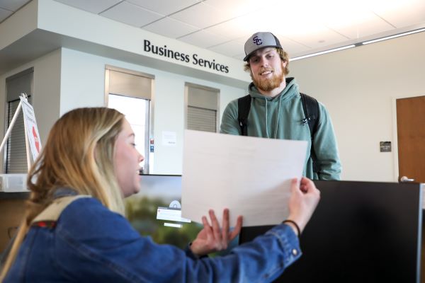 !A student receives help from a registration clerk.