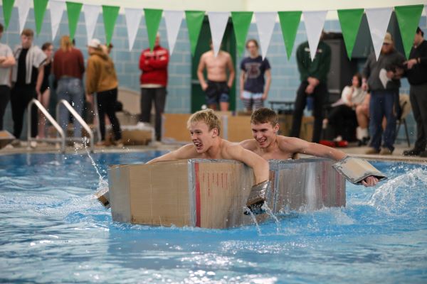 Students paddle a cardboard boat