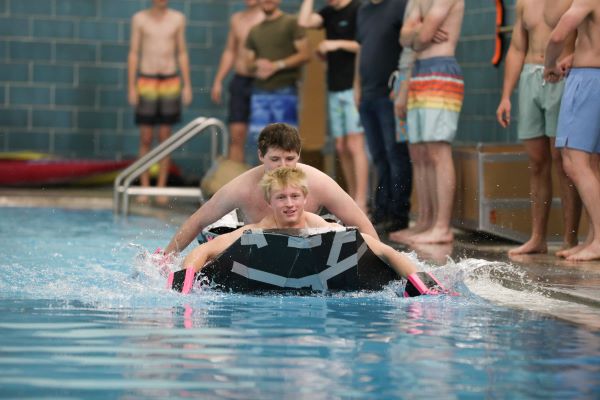 Students paddle a cardboard boat