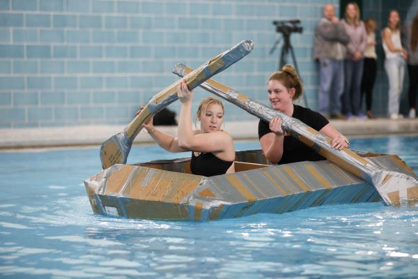 Students paddle a cardboard boat