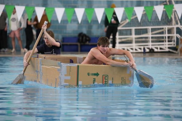 Students paddle a cardboard boat