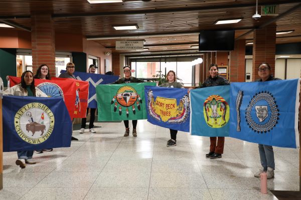 Students hold tribal flags. 