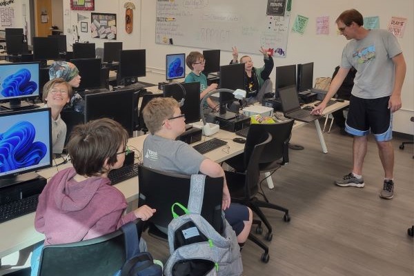 Joel Graff works with students in a computer lab