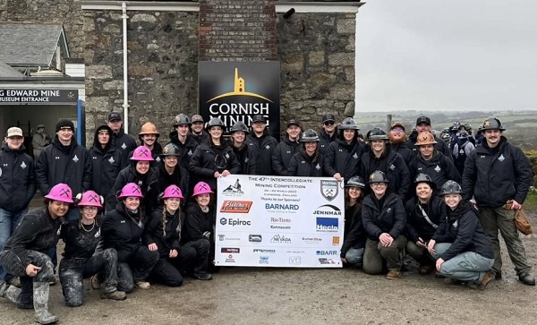 A large group of students in hardhats pose for a photo.. 