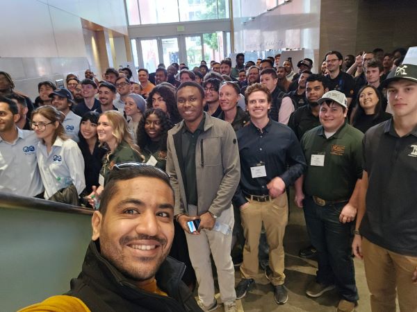 Assistant Professor Foued Badrouchi takes a selfie with a large group of students