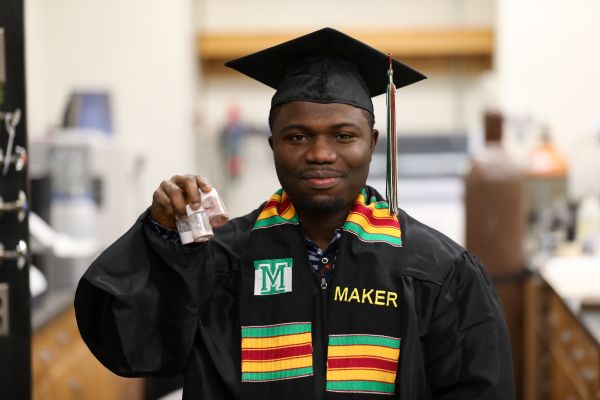 Isaac Joseph Cobbinah in his cap and gown in the lab