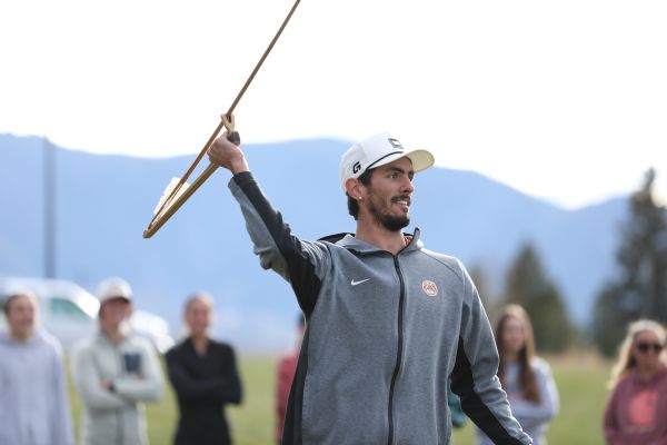 A student tosses an atlatl.