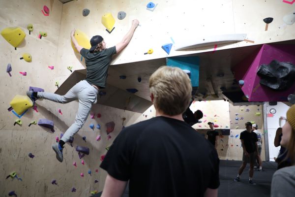 A student climbs in the climbing gym