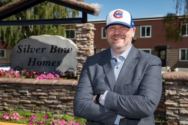 Dr. Rick LaDouceur stands in front of a Silver Bow Homes sign