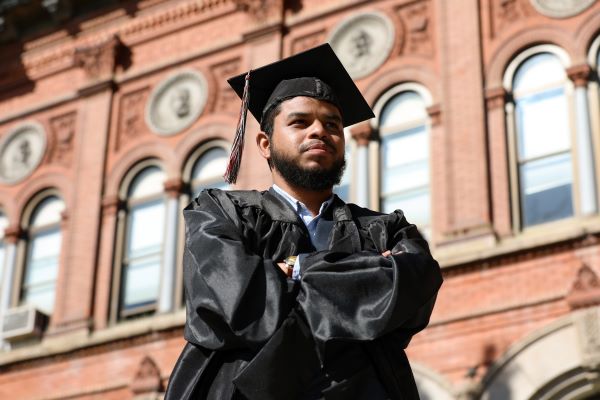 !Umaer Zaki poses for a photo in cap and gown