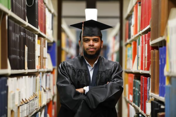 Umaer Zaki poses for a photo in cap and gown