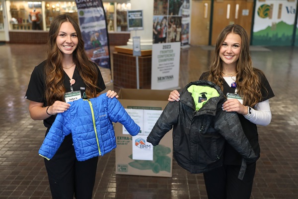 Students pose with small coats
