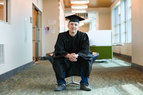 Nathan Ostwald poses in cap and gown