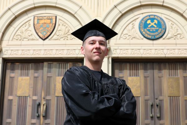 Nathan Ostwald poses in cap and gown