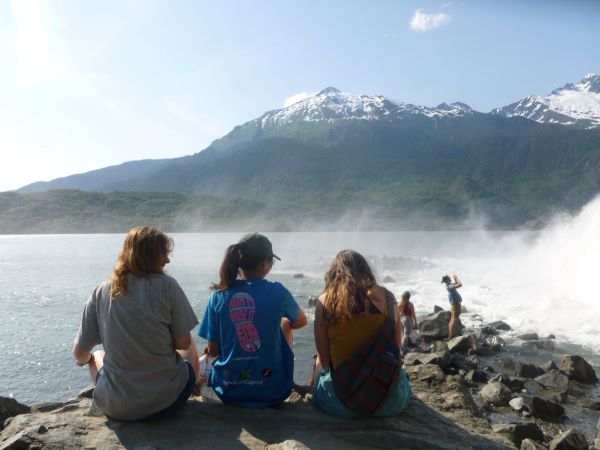 Students look at ocean and mountain.