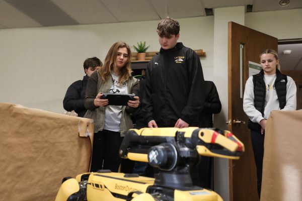 Four students work with SPOT, a mining robot