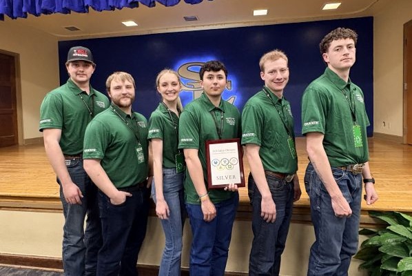 Safety Olympics team poses with their plaque