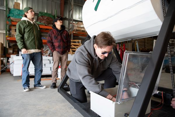 Two students work on their solar-powered composter.
