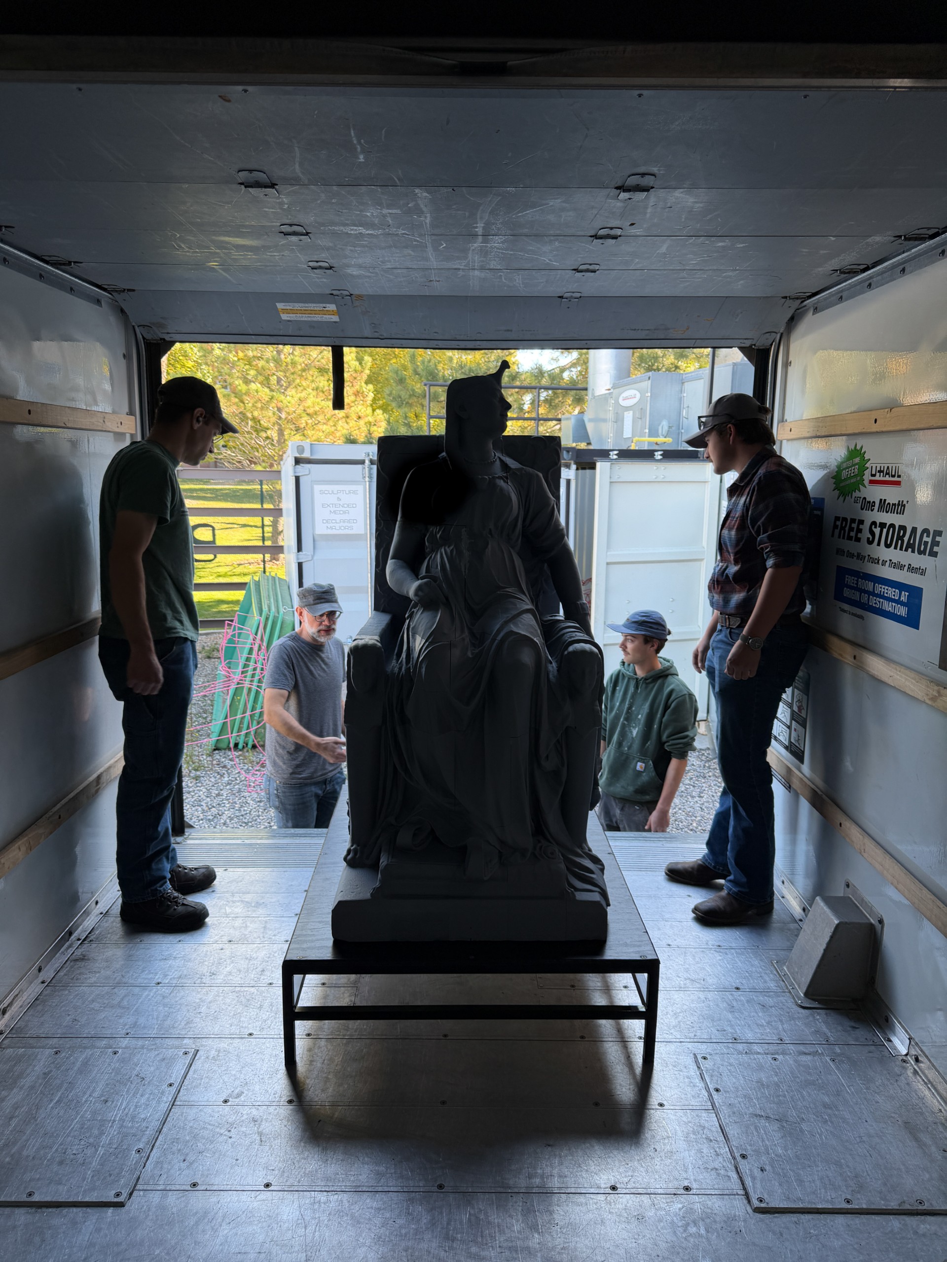 People unload the statue